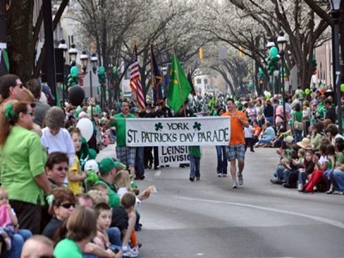 An image of people watching the St. Patrick's Day parade pass