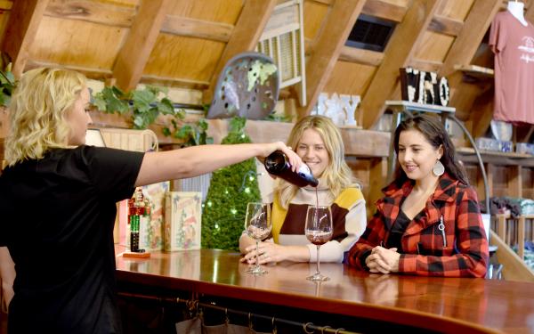 Woman pouring wine tastings at Huber's