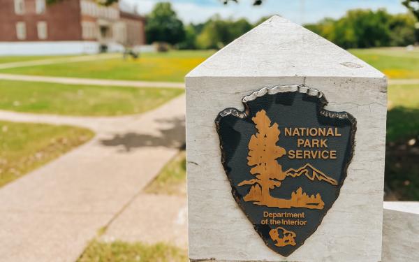 The National Park Service badge inlayed into a fence post at the Fort Smith National Historic Site.