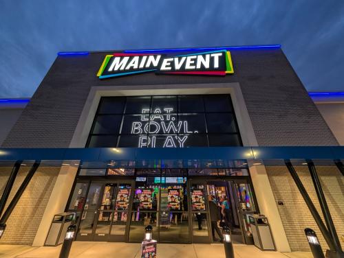 Main Event preview opening in Woodbury showing exterior signs lit up with "Eat. Bowl. Play"