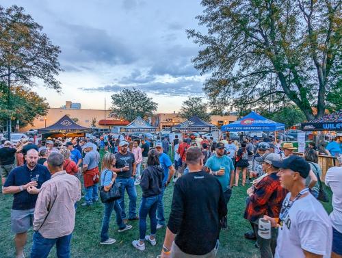 5 tents from various breweries and distilleries and the crowd of people at Oktoberfest 2023
