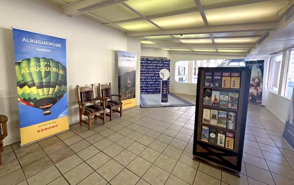 The interior of the Convention Welcome Center, featuring chairs, a brochure rack, banners, and a photo station.