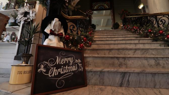 A painted chalkboard sign reading "Merry Christmas" sits on the steps of a gift shop in Wichita, KS