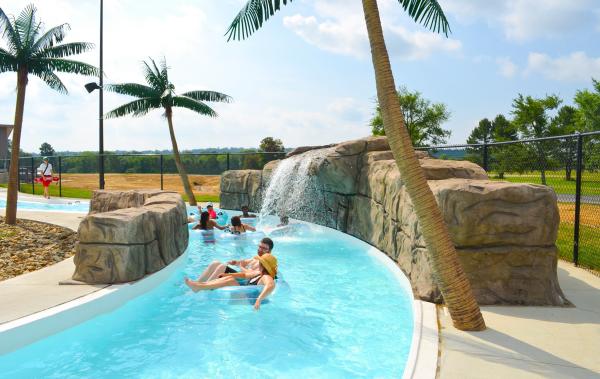 Children and adults float down a cool, blue lazy river at Parrot Island Water Park in Fort Smith.