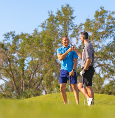 Two guys on Riverwood Golf Course in Port Charlotte Florida celebrating a good shot.