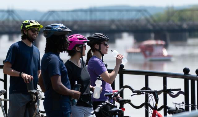Bikers on Riverfront w Riverboat Background