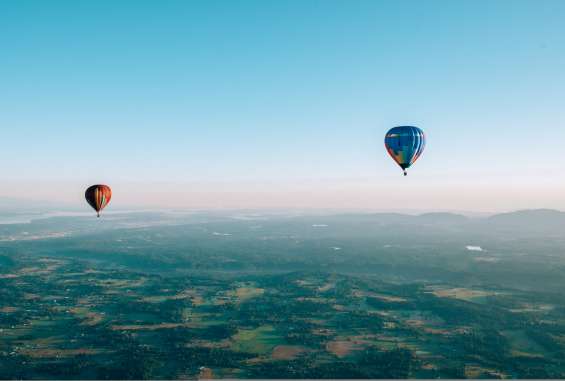 Passengers enjoy the scenic beauty of the Pacific Northwest from the basket of hot-air balloons.