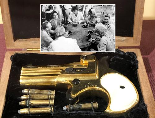 Ava's gold pistol in its case with insert photo of cast receiving the guns from John Huston