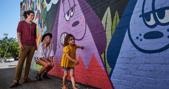 Family viewing the abstract and colorful murals of OKC's Plaza Walls