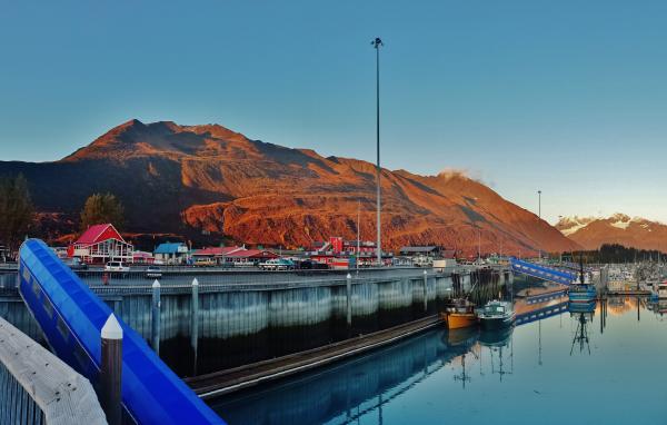 a harbor and a business district in Valdez. Mountains in background