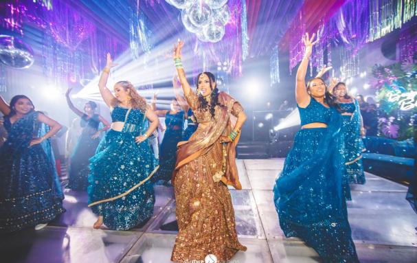 A bride dances with her bridesmaids at a traditional Indian wedding party