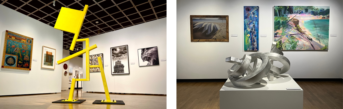 Interior view of Muskegon Museum of Art featuring a bold yellow geometric sculpture in the foreground and various artworks on the walls, including paintings and photographs. A sculpture of interlocking metal ribbons is displayed on a pedestal in the center of an art gallery. Behind it are three paintings hanging on the wall, each showcasing different styles and subjects.