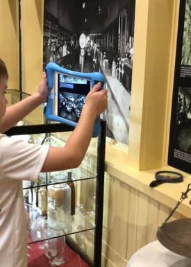 Boy using an iPad to look at a history exhibit
