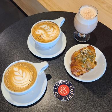 Lemma lattes with foam art, and a pistachio croissant