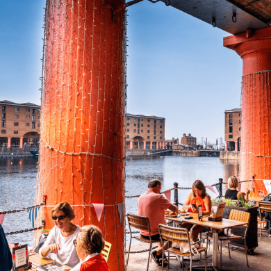 The Royal Albert Dock with people sitting at tables.