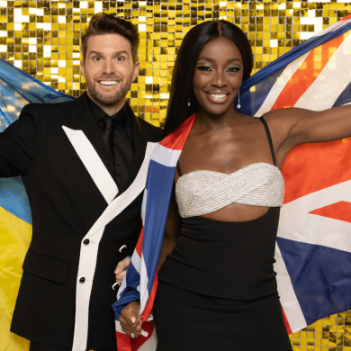 Joel Doel Dommett and Aj Odudu stodd in front of a gold glitter background holding a Union Jack flag and a Ukrainian Flag.