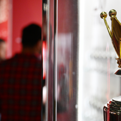 a close up shot of the Premier League Trophy in a glass case in a museum.