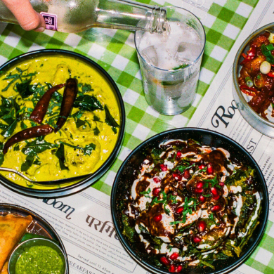 A selection of dishes with a glass of lemonade being poured. The tablecloth is green and white checked.