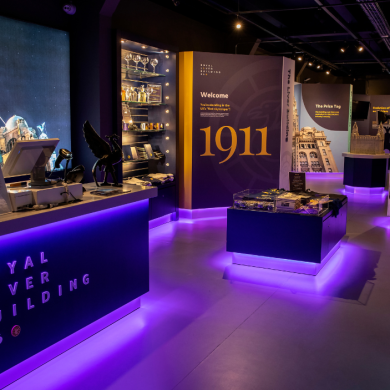 A reception area for RLB360 Tours, with low lighters of purple. The attraction has walls filled with historic facts on them.