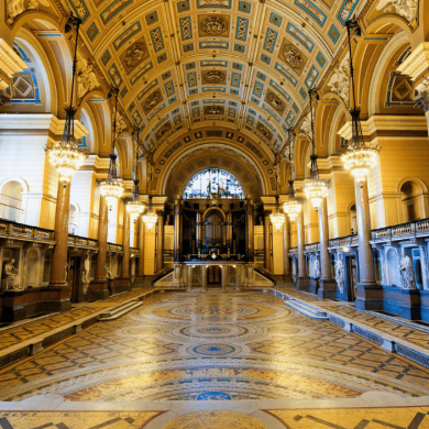 Inside St George's Hall with an intricate tiled flooring and ceiling.