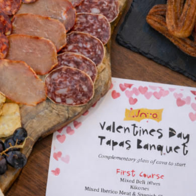 A cheese board with various meats and churros to celebrate Valentines Day.