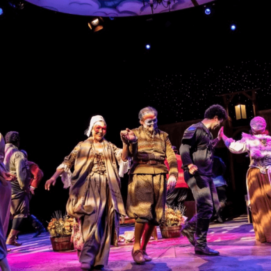 A stage with a cast of actors on.