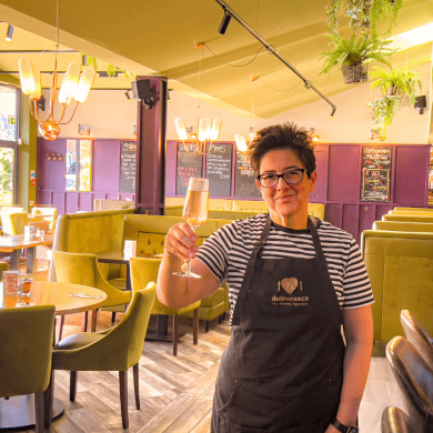 Inside Delifonseca with a person holding a glass of wine.
