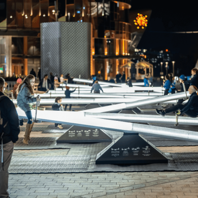 A line of see-saws lit up with people on them.