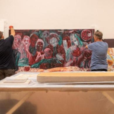 2 men holding up a painting