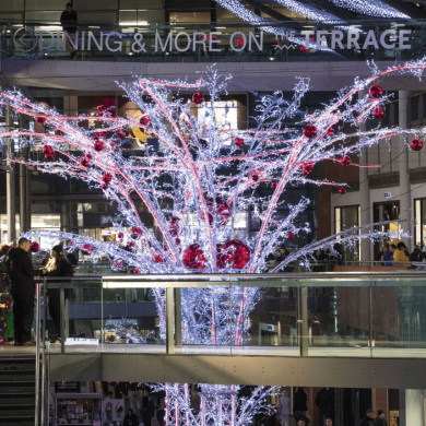 A large fake tree covered in white lights and red baubles at Liverpool ONE
