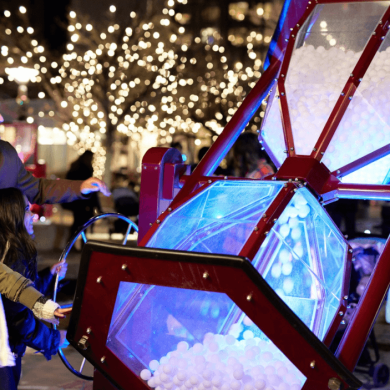 Two people playing with a large hour glass.