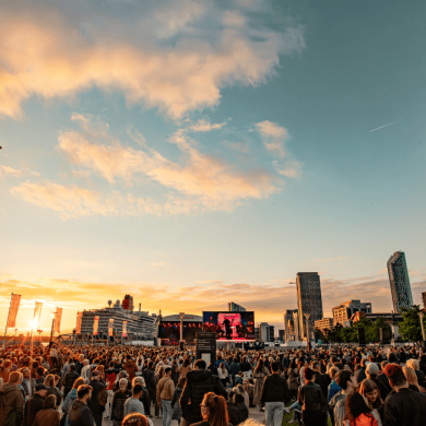 Liverpool Waterfront with a large crowd and a sunset in the background