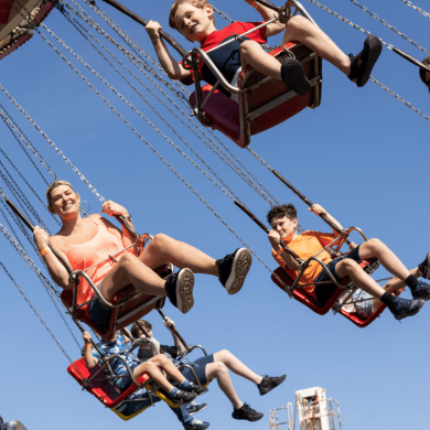 Five people on a swing fairground ride.