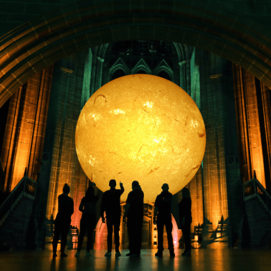 A large inflatable model of the sun hanging inside Liverpool Cathedral.