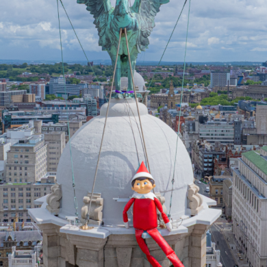 An elf on the shelf sat on top of the Liver Building