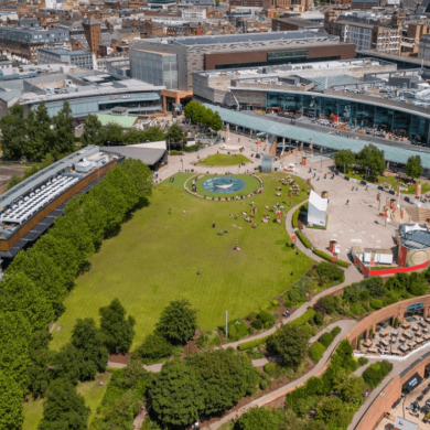A drone shot of Liverpool ONE from above with a shot of the park and buildings in the distance.