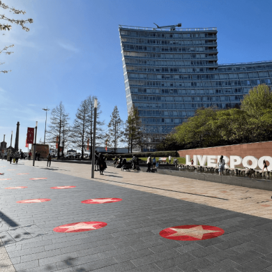 A path in Liverpool ONE shopping centre with red circles with stars on the floor in a 'Walk of Fame' style pattern.