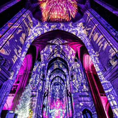 Inside Liverpool Cathedral lit up with a light show in purple and pink lights.