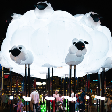 A large light installation in the shape of a cloud with sheep on it.