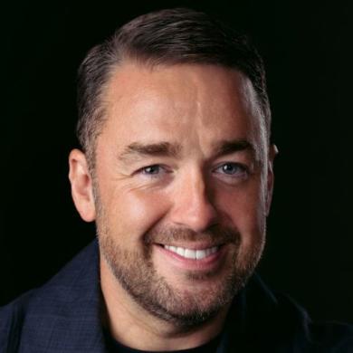 Jason Manford, comedian, against a black backdrop