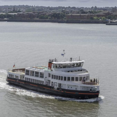 The Mersey Ferry sails on the River Mersey with Wirral in the background.