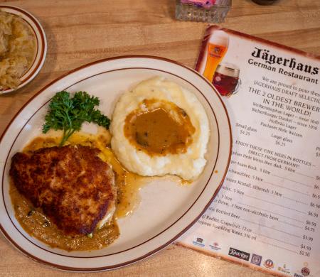 Image of a plate of food next to a menu from Jagerhaus