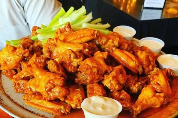 Anchor Bar A plate full of buffalo wings with celery and cups of blue cheese