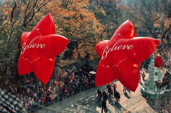 Macy's Thanksgiving Day Parade Two red star balloons with the word "Believe" written in cursive float along the Macy's Thanksgiving Day Parade route