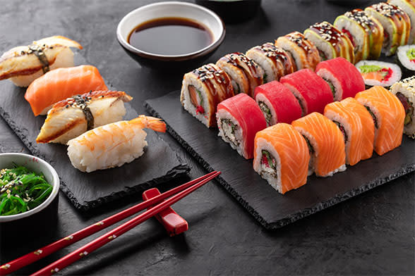 Plates of sushi rolls and chopsticks