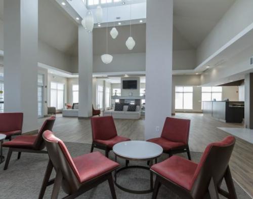 Red chairs around a white table in a white painted lobby at the Hilton Garden Inn Elkhart