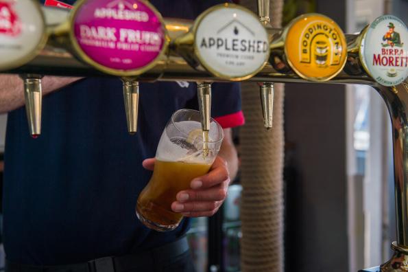 an image of a pint of beer being poured in a pub