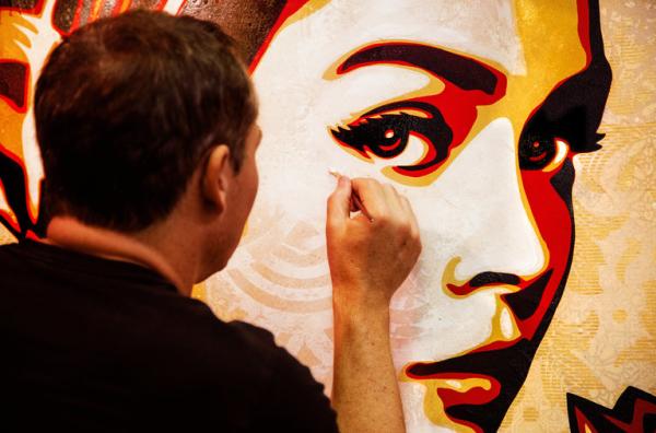 Shepard Fairey creating a wall mural of a beautiful woman