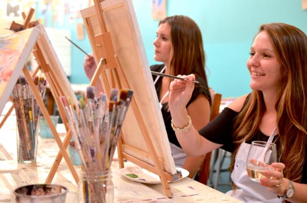 Two girls painting on canvas at Studio 614
