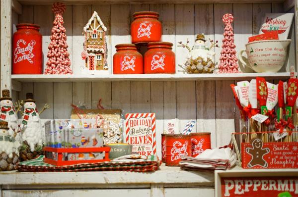 Holiday display with red and white ceramic jars, Christmas trees, and gingerbread houses at The Woods